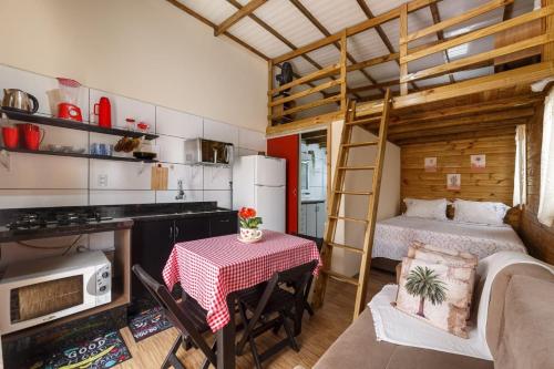 a small kitchen with a table and a bunk bed at Casa Perto das melhores praias Florianópolis, 8 pessoas, ar condicionado, tv, wifi, cozinha completa, lavanderia, in Florianópolis