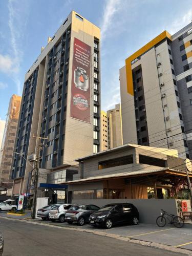 een groep auto's geparkeerd voor een gebouw bij Studio moderno Alu lounge 103 in São Luís