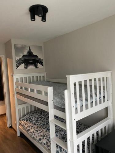 a bedroom with two white bunk beds and a mirror at Homeawayfromhomeghent with private parking in Ghent