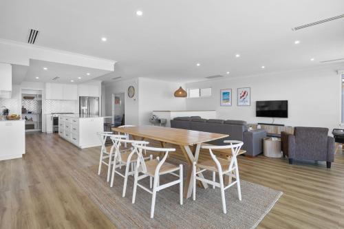 a kitchen and living room with a wooden table and chairs at Norman Views - 20 Panorama Crescent in Normanville