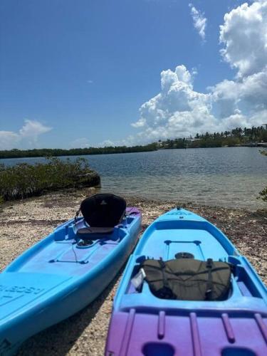 two boats sitting on the shore of a body of water at Beach View Room at Barnacle Resort in Big Pine Key