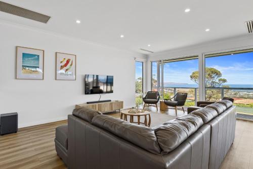 a living room with a large couch and a tv at Norman Views - 20 Panorama Crescent in Normanville