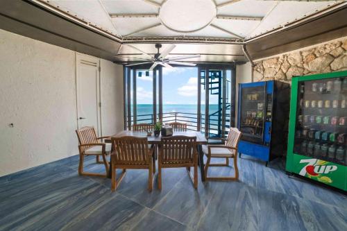 a dining room with a table and chairs and the ocean at Beach View Room at Barnacle Resort in Big Pine Key