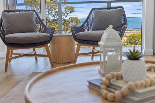 a living room with two chairs and a coffee table at Norman Views - 20 Panorama Crescent in Normanville