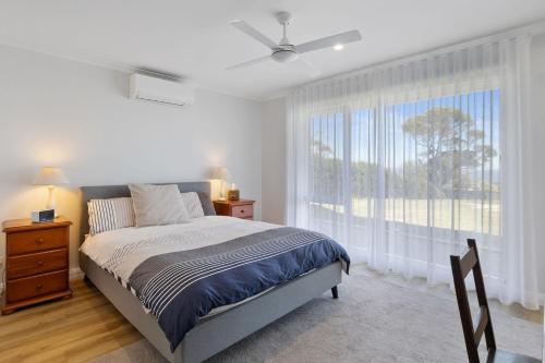 a bedroom with a bed and a large window at Norman Views - 20 Panorama Crescent in Normanville