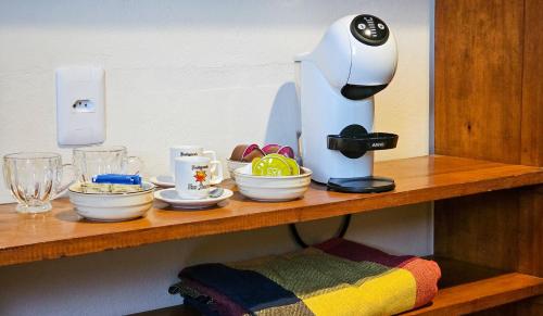 einen Tisch mit Kaffeemaschine auf einem Regal in der Unterkunft Sunset Suite in Resende