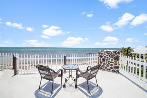 a table and two chairs on a balcony with the beach at Star Room at Barnacle Resort in Big Pine Key
