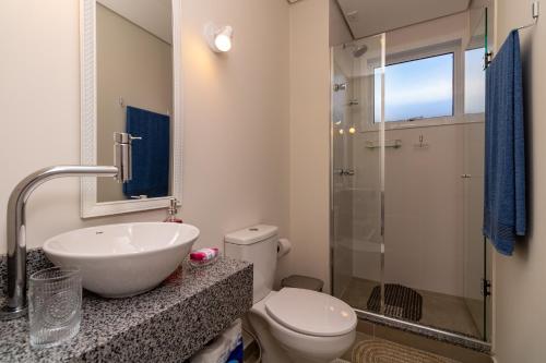 a bathroom with a sink and a toilet and a shower at Mood Independência in Passo Fundo