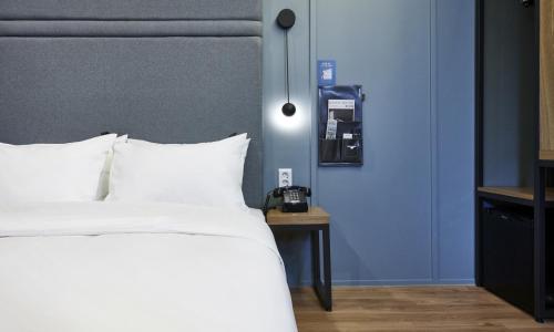 a bedroom with a white bed and a blue wall at JustSleep Namyangju Dasan in Namyangju