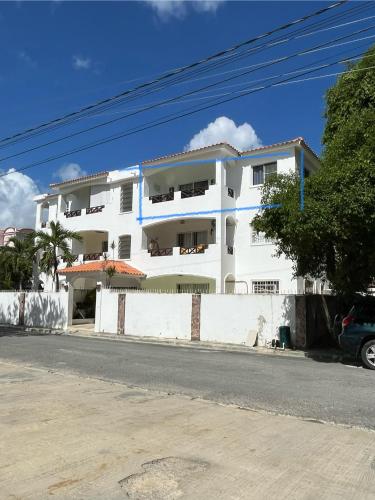 a white building on the side of a street at Apto CGM Esmeralda in Bayahibe
