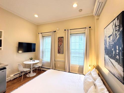 a bedroom with a white bed and a table at Copley House in Boston