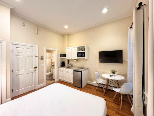 a bedroom with a bed and a kitchen with a table at Copley House in Boston
