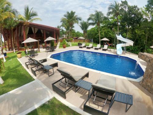 a swimming pool with chairs and a slide at Delta Maresias Club by Smart Sharing in Maresias