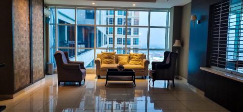 a living room with a couch and two chairs at Apt Roseville Soho BSD 1 BR Mezzanine with Netflix & Pool by Damaresa in Dadap