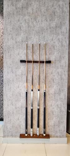 four baseball bats lined up against a wall at Apt Roseville Soho BSD 1 BR Mezzanine with Netflix & Pool by Damaresa in Dadap