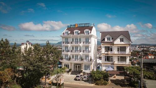 a tall white building with a roof at Dalat Roof Hotel in Da Lat