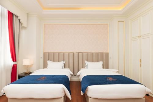 two beds sitting next to each other in a room at THE PREMIER PALACE HOTEL AND SPA in Phnom Penh