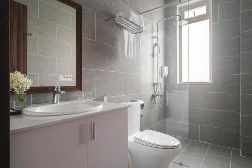 a bathroom with a toilet and a sink and a mirror at Dalat Roof Hotel in Da Lat