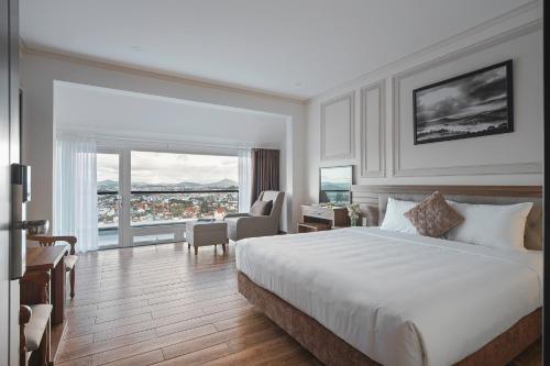 a hotel room with a bed and a large window at Dalat Roof Hotel in Da Lat