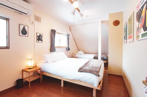 a bedroom with a white bed and a window at South Furano House in Furano