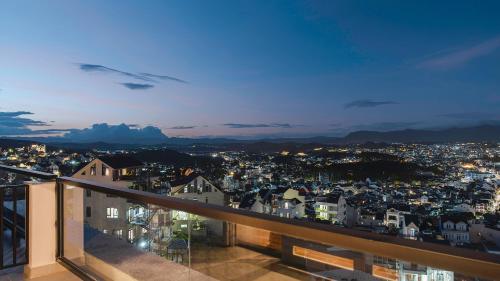 a view of a city at night from a balcony at Dalat Roof Hotel in Da Lat