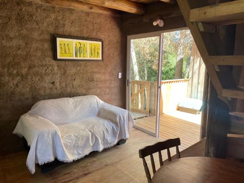 - une chambre avec un lit et une couverture blanche dans l'établissement Cabaña lo de Antonia, à Estación Costa Azul