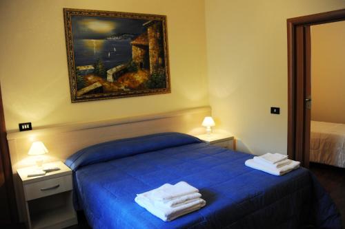 Un dormitorio con una cama azul con toallas. en L'Antica Dimora, en San Pietro Vernotico