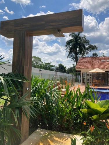 a wooden structure in a garden with a pool at Doral House Villavicencio in Villavicencio