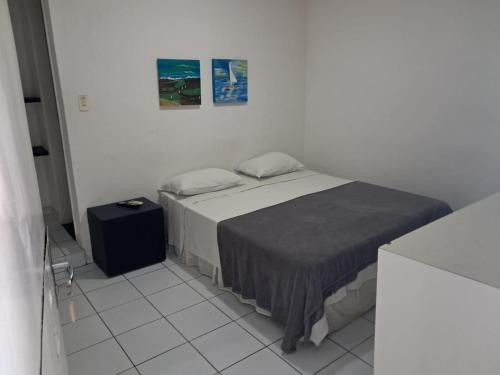 a white room with a bed and a table at Pousada Recife Tropical in Recife