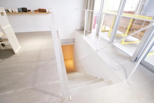 a white staircase in a room with windows at まえばしガレリアArt residence & Hotel in Maebashi