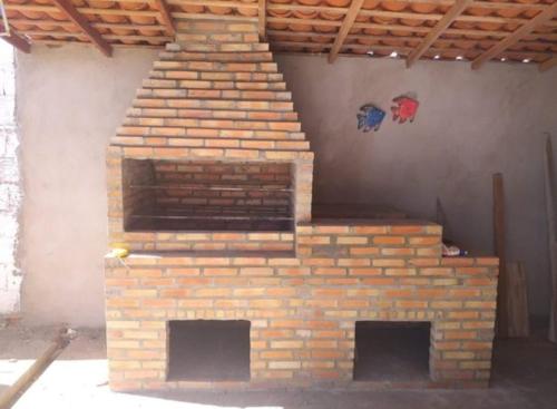 a brick fireplace in a building with two openings at Casa de praia in Luis Correia