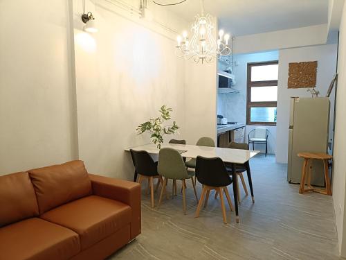 a living room with a couch and a table and chairs at Grey Brown Green house at chiangmai old town in Chiang Mai