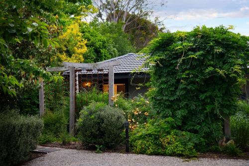 a garden with a pergola in front of a house at East Street Datlesford in Daylesford