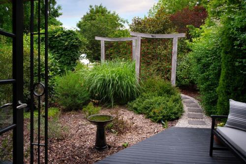 a garden with a wooden walkway and a pergola at East Street Datlesford in Daylesford