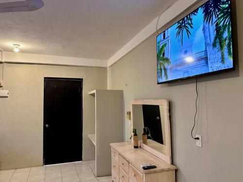 a living room with a flat screen tv on the wall at Casa Vidal Hotel in Valladolid