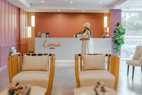 a woman in a white dress standing at a counter at Lima Hotel in Phra Nakhon Si Ayutthaya