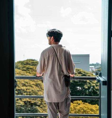 a man looking out the window of a building at Lima Hotel in Phra Nakhon Si Ayutthaya