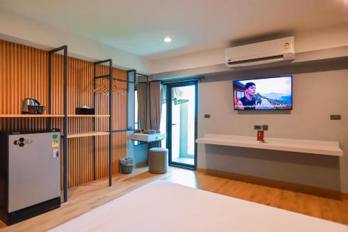 a living room with a tv on the wall at Lima Hotel in Phra Nakhon Si Ayutthaya