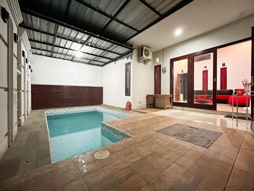 a swimming pool in the middle of a living room at Oma Kost 3 Probolinggo Mitra RedDoorz in Probolinggo
