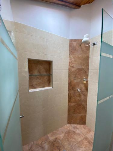 a bathroom with a shower with a glass door at Cabaña Campestre - Puente Nacional in Puente Nacional