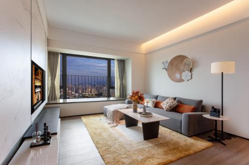 a living room with a couch and a table at Ascott Fengyishan Shenzhen in Shenzhen