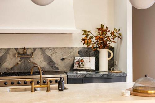 a kitchen with a sink and a vase with a plant at Muskoka Luxe Retreat with Pool Spa & Fire Pit in Mount Martha