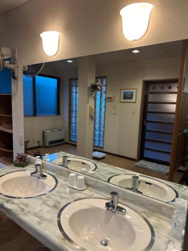 a bathroom with three sinks and a large mirror at 令德湖畔山荘 in Yamanakako