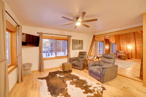 a living room with two chairs and a ceiling fan at Studio Steps to Kenai River with Fire Pit! in Sterling