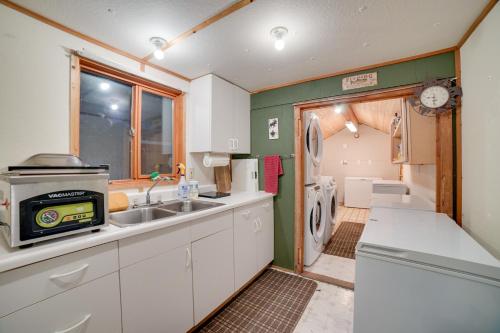 a kitchen with a sink and a refrigerator at Studio Steps to Kenai River with Fire Pit! in Sterling