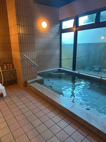 a bathroom with a jacuzzi tub with a window at 令德湖畔山荘 in Yamanakako