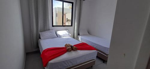 a small room with two beds and a window at Apartamento no NDM Bessa in João Pessoa