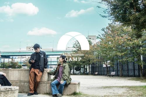 people sitting on a wall in front of the gateway arch at Fukuoka Guesthouse CAMP in Fukuoka