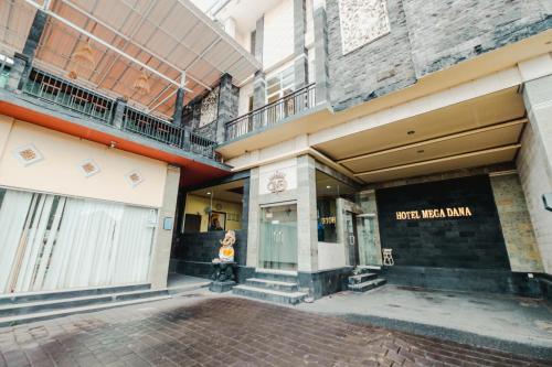 a store front of a building with a woman standing outside at Hotel Mega Dana in Kesiman