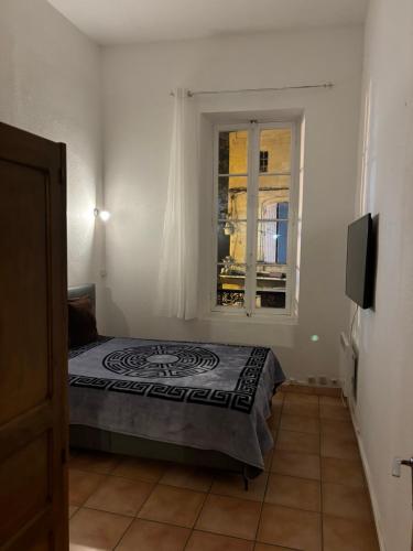 une chambre avec un lit et une fenêtre dans l'établissement Appartement centre historique, à Tarascon